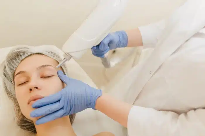 a woman receiving a laser skin rejuvenation treatment at an aesthetic clinic