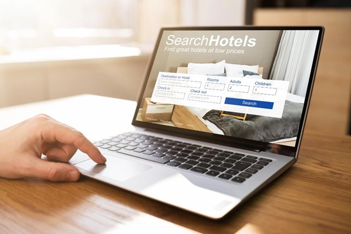 Person searching for holiday accommodation on a laptop using an online hotel booking website