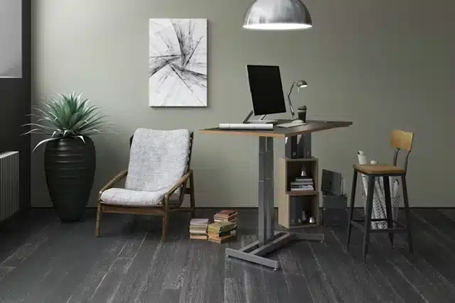 Compact standing desk with monitor, built-in shelf, and ergonomic chair in small student bedroom