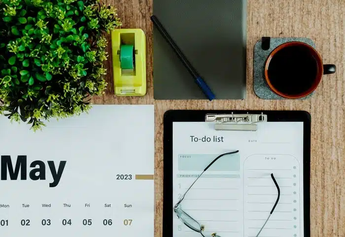 Desk with a to-do list, calendar, and coffee, breaking a big change into smaller daily steps