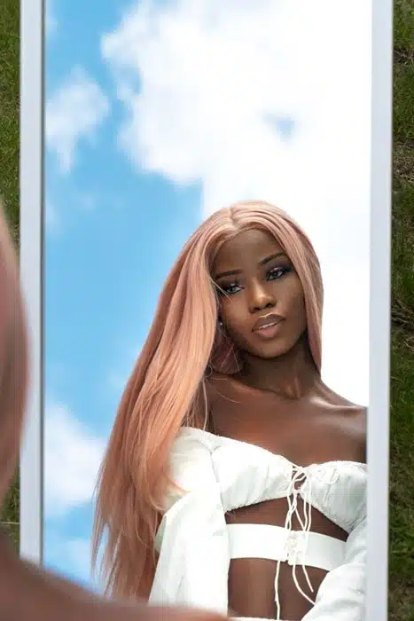 Sleek pink wig styled straight, offering a secure fit for outdoor summer days