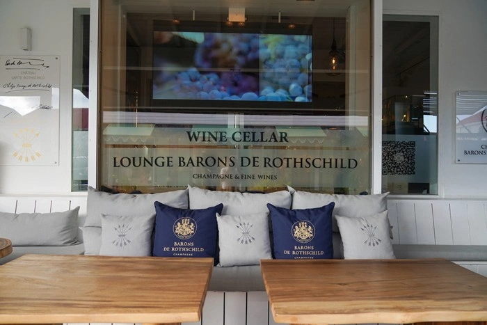 Elegant lounge seating and wine cellar signage at Barons de Rothschild, a luxury champagne bar in St Barts