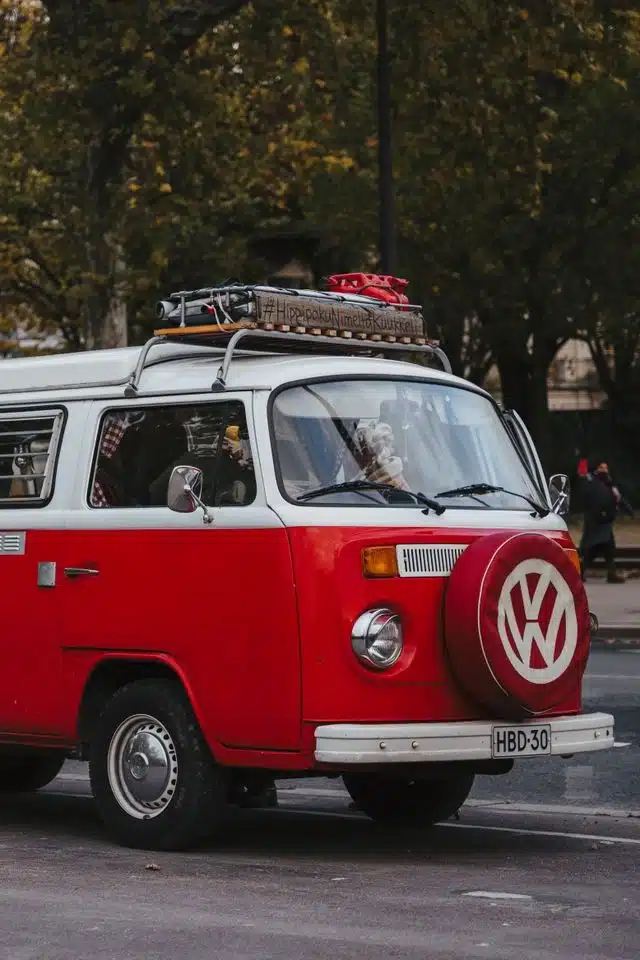 Red campervan with roof rack packed for a luxury camping road trip