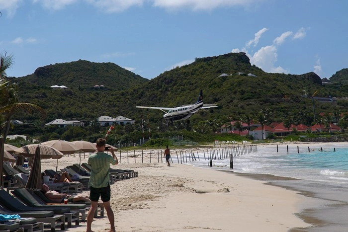 Small plane landing over St Barts beach, a famous sight for travelers arriving on the island