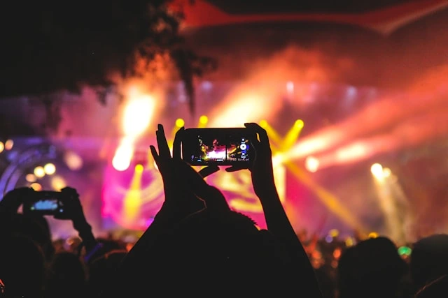 Guest capturing a live event on smartphone, an example of online photo sharing for events in action