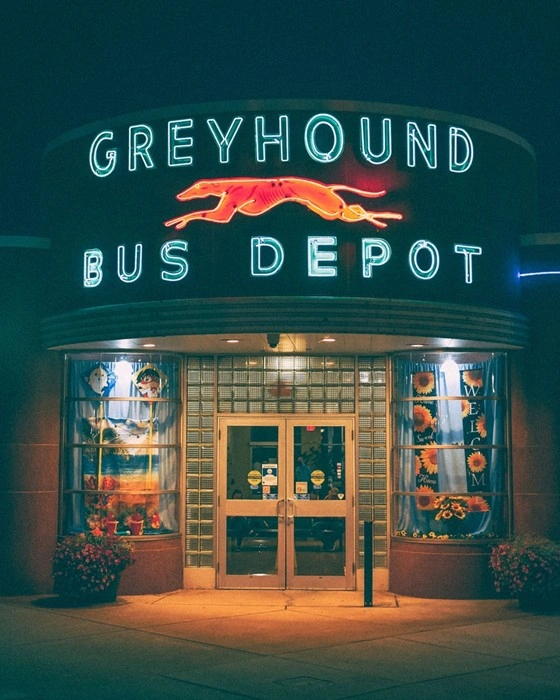 Greyhound bus depot with illuminated neon sign at night in Virginia