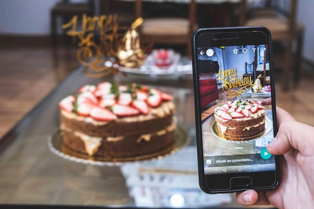Guest photographing a birthday cake to post through photo sharing at the celebration