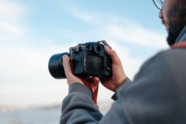 Professional photographer using a DSLR camera to capture event moments outdoors