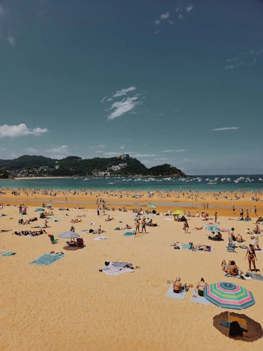 Sunbathers fill La Concha beach in San Sebastián during peak summer in the Basque Country