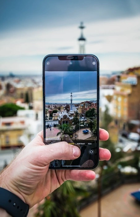 Traveler photographs Park Güell in Barcelona on a smartphone while staying connected abroad