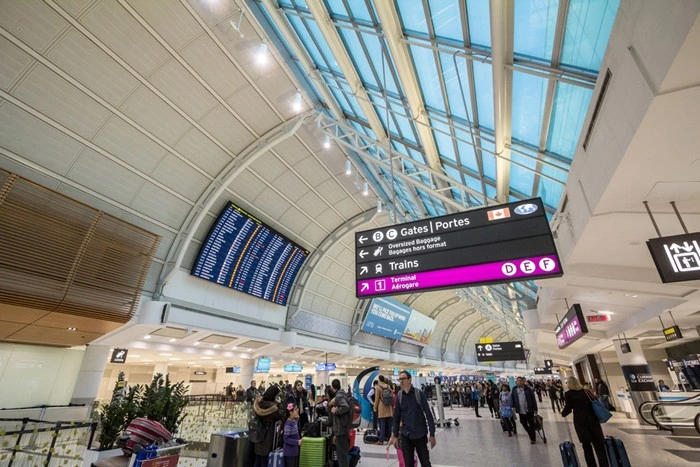 Toronto international airport terminal with gate signs and travelers preparing for data plan setup