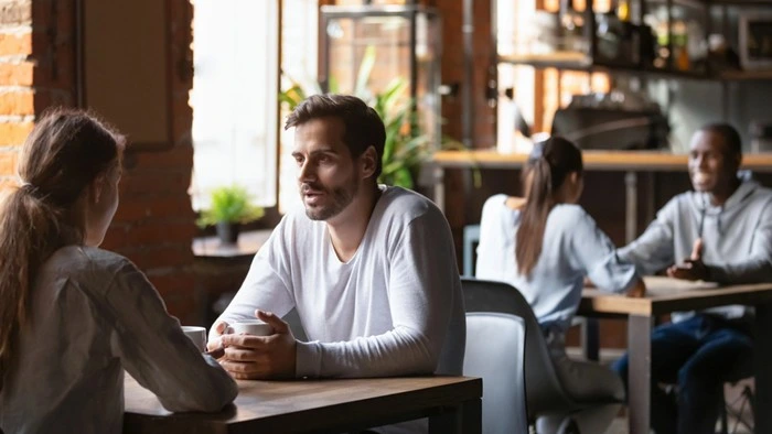 Two couples having conversations with potential matches at a café dating event