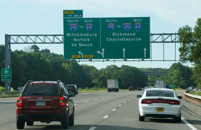 Williamsburg to Richmond road trip highway sign showing I-64 and I-295 exits toward Williamsburg, Norfolk, Richmond, and Charlottesville