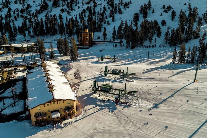 Aerial view of Kirkwood lodging and ski resort surrounded by snow-covered mountains