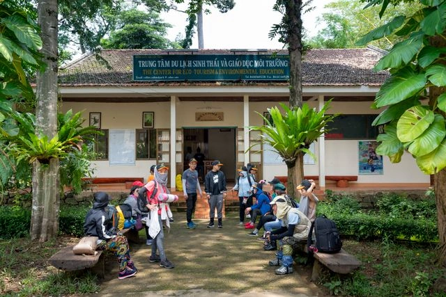 Group of ecotourism travelers resting outside a local eco-tourism education center