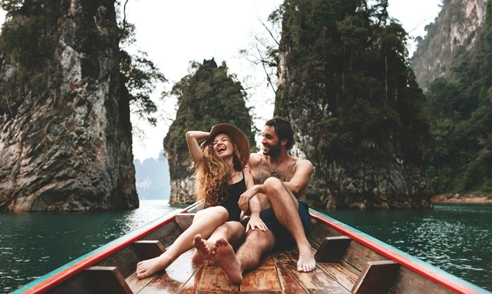 Couple laughing together on a boat ride through a scenic limestone lagoon