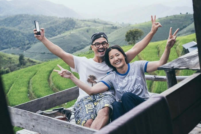 Playful couple taking a selfie together overlooking scenic rice terraces