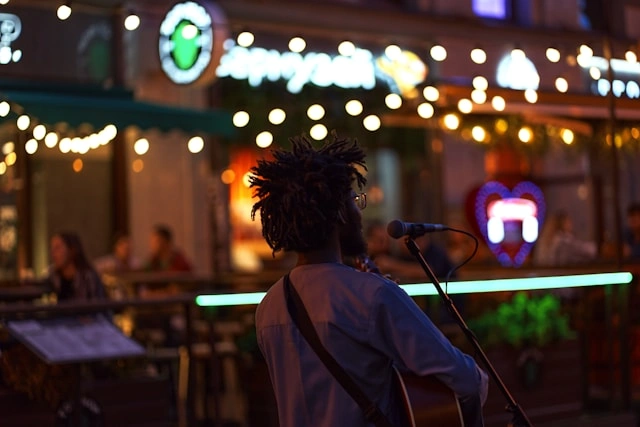 Street musician performing near an outdoor cafe, adding live entertainment to the dining experience