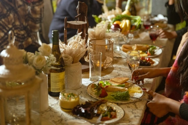 Rustic outdoor table set with wine, wildflowers, and shared plates for an experiential dining for travel experience