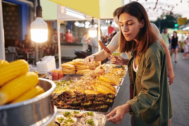 Traveler exploring a street food market stall as part of a guided food tour experience