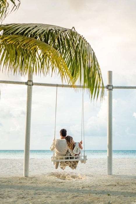 How to elevate your couple's getaway with a beachside swing under a palm tree