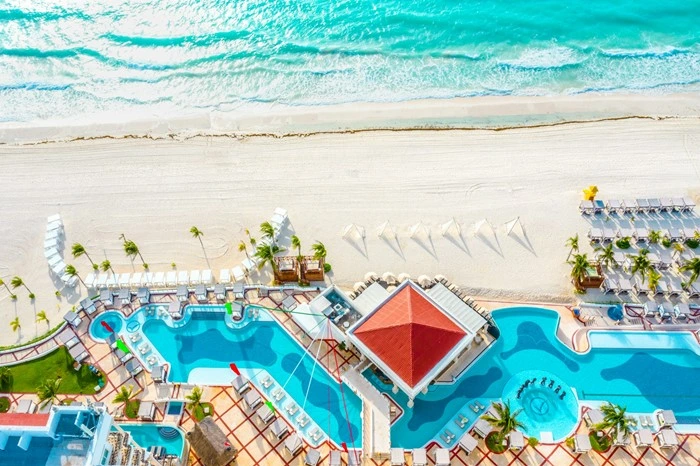 Aerial view of an adults-only resort pool area near Playa Mujeres, Cancun with beachfront cabanas