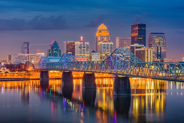 Louisville, Kentucky downtown skyline lit up at night with a bridge crossing the Ohio River