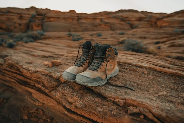 Sturdy travel boots for men resting on rugged red rock terrain