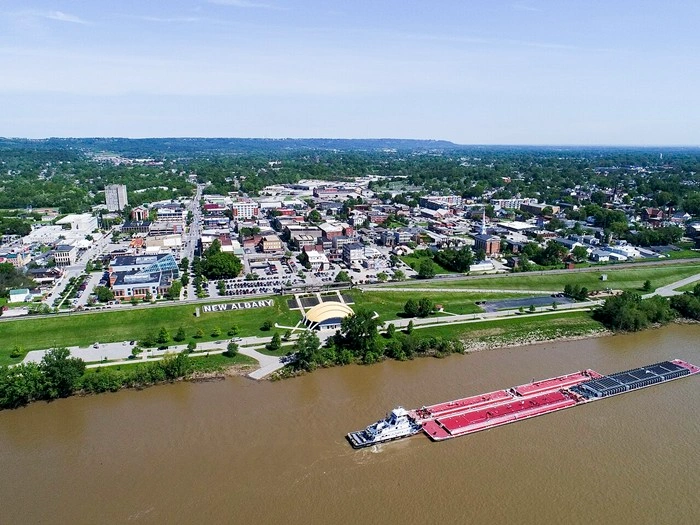 Aerial view of New Albany, Indiana along the Ohio River with a barge passing through