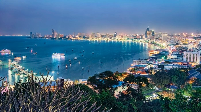 Aerial view of Pattaya Bay lit up at night, a coastal city balancing energy and calm