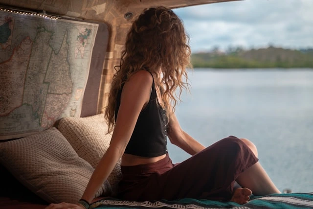 Woman relaxing by a map, planning her solo travel adventure with a scenic water view