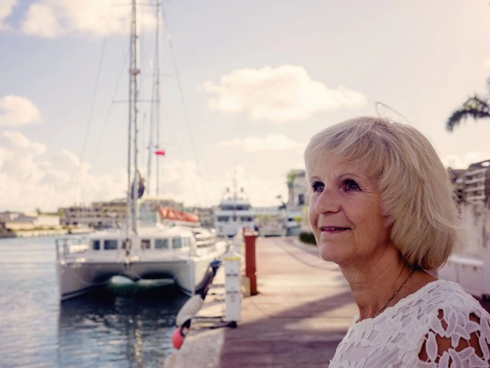 Senior traveler visiting Cancun and enjoying a relaxed view of the marina and yachts