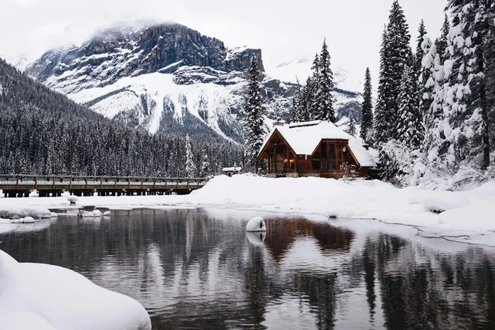 Snow-covered wooden cabin lodging near a lake in Kirkwood, California