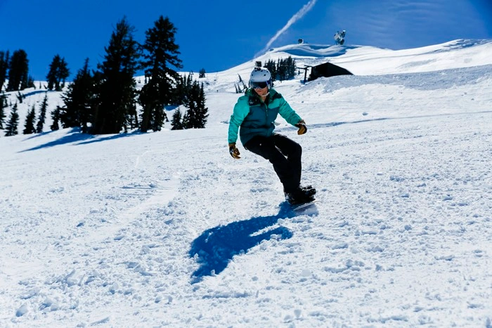 Snowboarder carving down a slope near Kirkwood, California