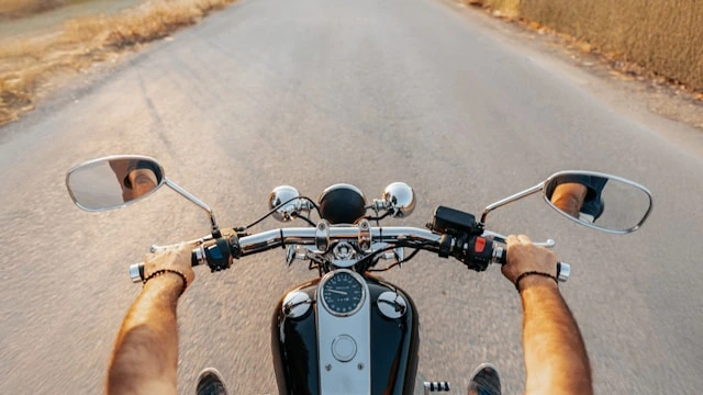 Why riding a motorbike feels freeing — rider's-eye view of the handlebars on an open road