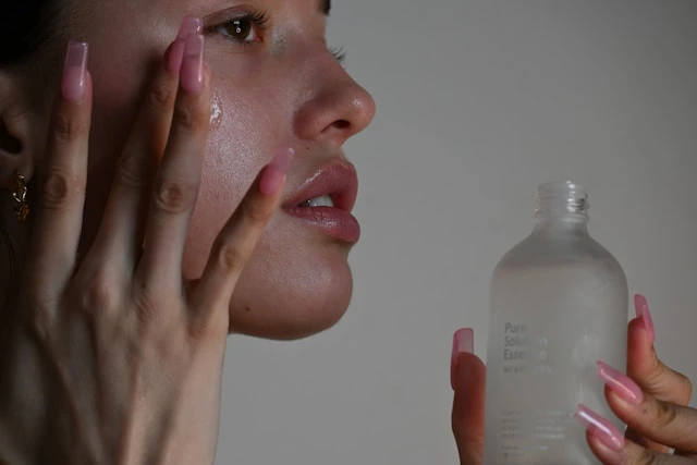 Applying travel-friendly skincare essence for a comfort self-care routine abroad