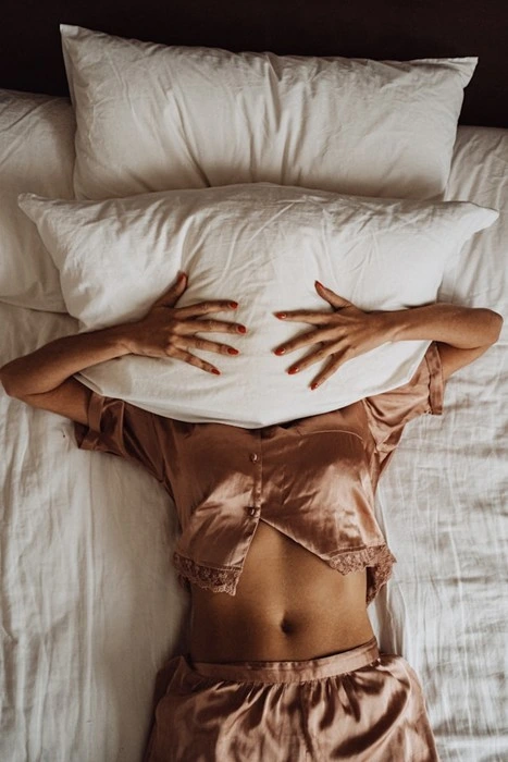 Woman resting in silk pajamas for a good night's sleep during solo travel
