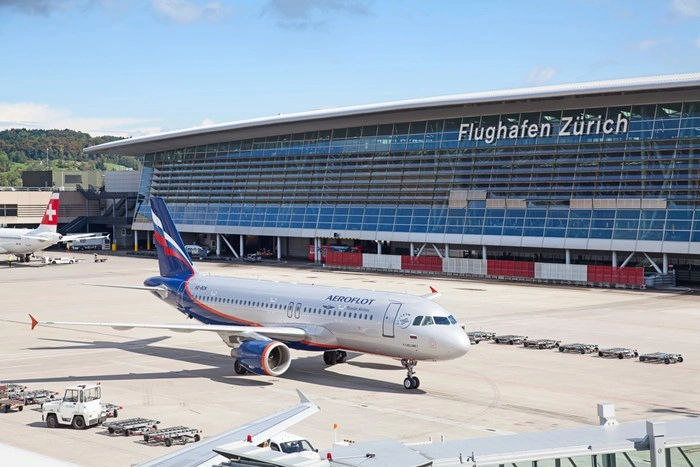 Exterior view of Zurich Airport with an aircraft on the tarmac, the starting point for any Zurich chauffeur pickup or limousine transfer.