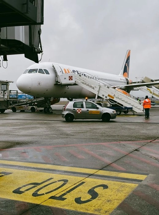 Ground staff and service vehicle beside a plane at Zurich Airport, part of the coordinated Zurich airport transfer process for arriving passengers.