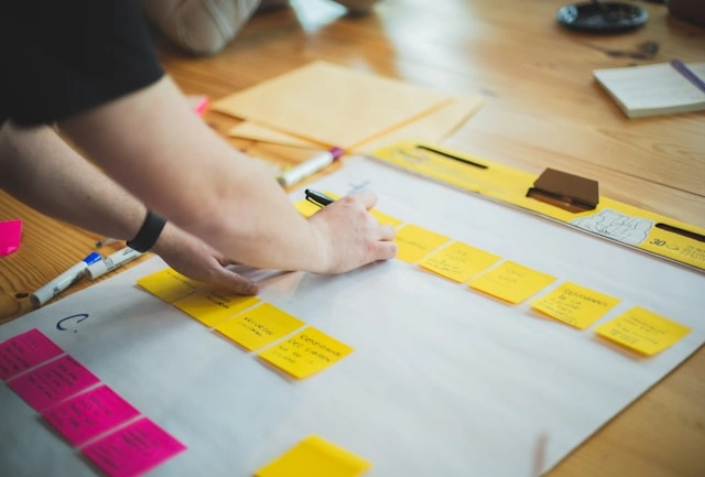 How to Boost Your Career with Strategic Industry Placements: person organizing sticky notes on a planning board