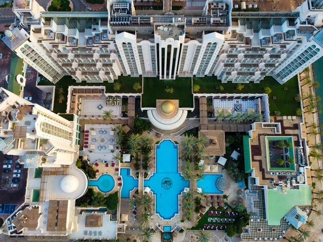 Aerial view of large luxury resort complex with pools, gardens, and multiple guest wings