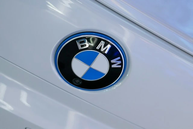 Close-up of a BMW roundel badge with a blue outer ring on glossy white body paint