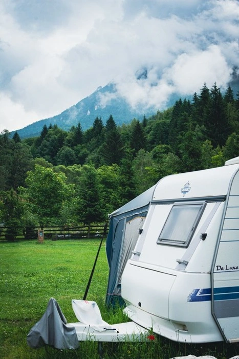 Caravan parked at a campsite in Brasov, Romania, with mountain views