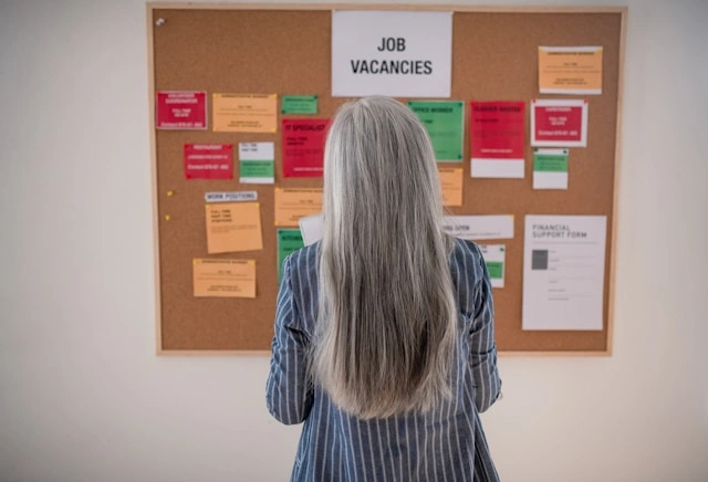 Professional woman reviewing job vacancies and career opportunities on a bulletin board
