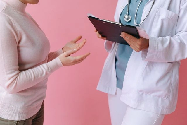 Patient discussing port injury symptoms with doctor holding clipboard
