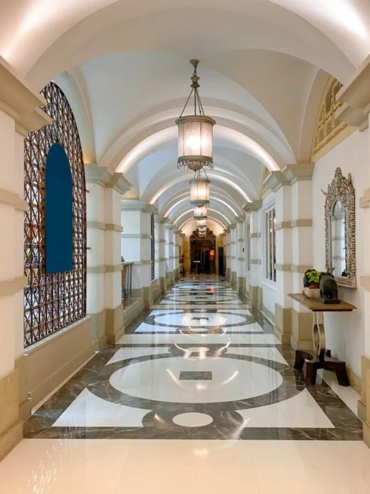 Ornate marble hallway with arched ceilings and chandeliers inside a luxury hotel