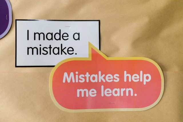 Sign reading 'I made a mistake' next to speech bubble 'Mistakes help me grow,' showing failure as a lesson