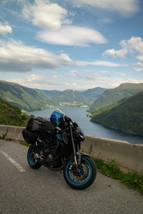 Packed motorcycle parked overlooking a fjord on a mountain road