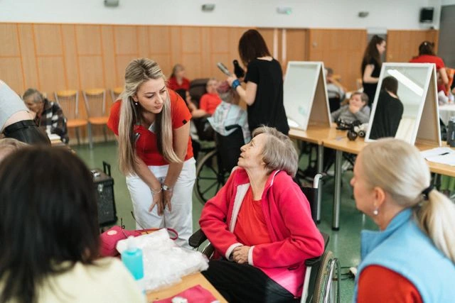 Caregivers assisting elderly residents during a group activity in a nursing home