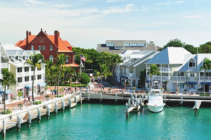Pier in Key West with waterfront shops, palm trees, and a docked fishing boat